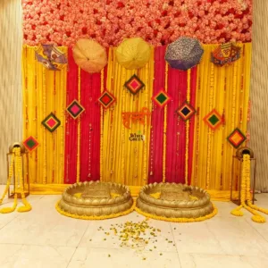 Traditional Haldi Decoration – Yellow & Red Floral Backdrop with Single Haldi Urli Tub